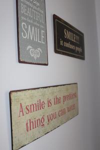 a smile is the prettiest thing you can wear signs on a wall at paclera79 in Santa Maria Val Müstair