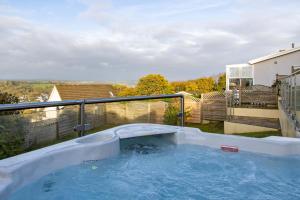 a hot tub on top of a balcony at Golwg Y Môr - Sea View Cottage with Hot Tub in Saundersfoot