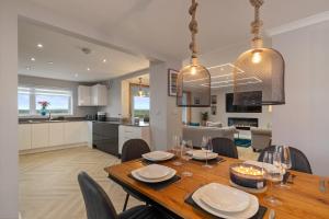 a dining room and kitchen with a table and chairs at Golwg Y Môr - Sea View Cottage with Hot Tub in Saundersfoot