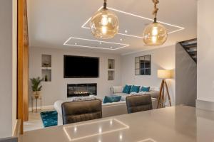 a living room with a couch and a tv at Golwg Y Môr - Sea View Cottage with Hot Tub in Saundersfoot