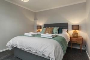 a bedroom with a large bed with two lamps at Golwg Y Môr - Sea View Cottage with Hot Tub in Saundersfoot +32 photos