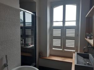 a bathroom with a window and a sink and a toilet at Appart de charme 100 m2 centre ville in Rennes