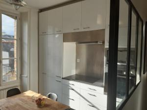 a kitchen with white cabinets and a wooden table at Appart de charme 100 m2 centre ville in Rennes