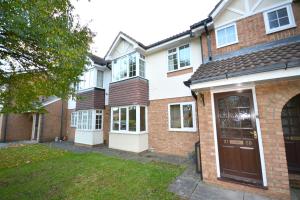 a large brick house with a brown door at Redmire - 2 bed 1st floor flat overlooking green in Darlington