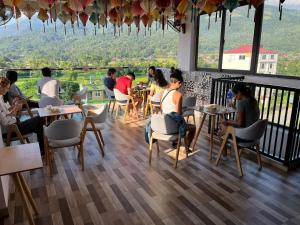 a group of people sitting at tables in a restaurant at Ha Giang Hostel in Ha Giang