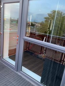een glazen schuifdeur met uitzicht op een balkon bij Lakeside 2 BED LUXURY APARTMENT No PARTIES No EVENTS Early Check-in Late Check- Out Allowed in West Thurrock
