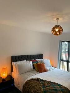 a bedroom with a bed and a lamp and a light at Lakeside 2 BED LUXURY APARTMENT No PARTIES No EVENTS Early Check-in Late Check- Out Allowed in West Thurrock
