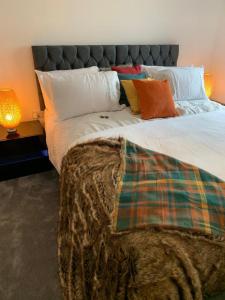 een slaapkamer met een groot bed met kussens bij Lakeside 2 BED LUXURY APARTMENT No PARTIES No EVENTS Early Check-in Late Check- Out Allowed in West Thurrock