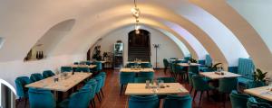 een restaurant met blauwe stoelen en tafels in een kamer bij Schlosshotel Erwitte in Erwitte