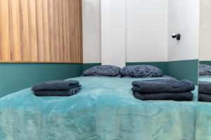 uma cama com algumas almofadas em cima em Uroczy, przytulny apartament poddasze em Radom