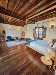 a bedroom with a large bed and a living room at Casa del Armiño Mansión de la Familia de "El Greco" in Toledo
