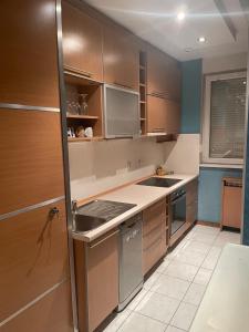 a kitchen with wooden cabinets and a refrigerator at Nebo in Novi Beograd