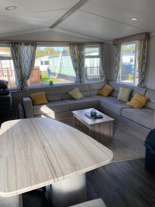 a living room with a couch and a table at Swift Retreat Caravan - Morecambe in Morecambe