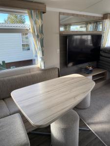 a living room with a table and a tv at Swift Retreat Caravan - Morecambe in Morecambe