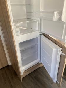 un frigorifero vuoto con la porta aperta in una cucina di Swift Retreat Caravan - Morecambe a Morecambe