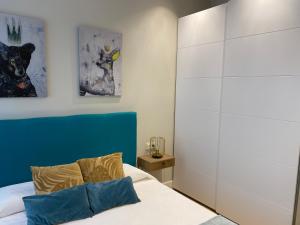 Un dormitorio con una cama con cabecero azul. en Apartamento Cielo del Norte VUT LE-933, en León