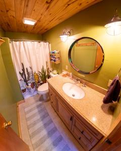 a bathroom with a sink and a toilet and a mirror at The Wanderlust Hostel in Gunnison