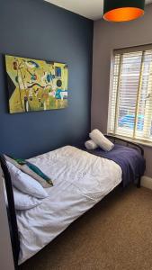 um quarto com uma cama com um quadro na parede em Worthingtons by Spires Accommodation A cosy and comfortable home from home place to stay in Burton-upon-Trent em Burton upon Trent