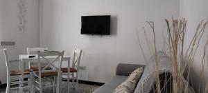 a living room with a couch and a tv on a wall at UltimoCasale in Matera