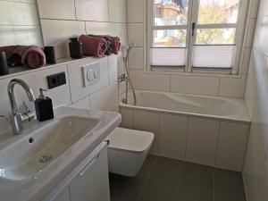 a bathroom with a sink and a toilet and a tub at Das goldene Haus in Sonthofen