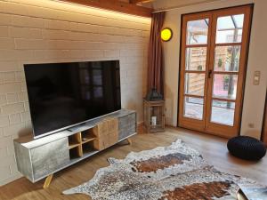 a living room with a flat screen tv on a brick wall at Das goldene Haus in Sonthofen