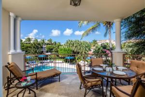 a patio with a table and chairs and a pool at Villa del Mar in Grace Bay