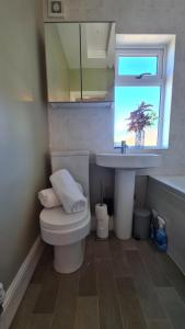 baño con aseo y lavabo y ventana en Worthingtons by Spires Accommodation A cosy and comfortable home from home place to stay in Burton-upon-Trent en Burton upon Trent