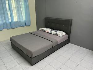 a bed with a black headboard in a bedroom at Homestay Malim Nawar in Malim Nawar