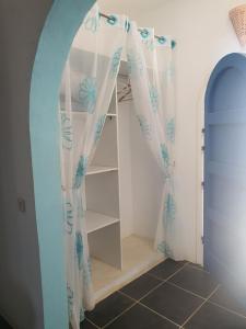 Zimmer mit einer Treppe mit Vorhängen und einem Regal in der Unterkunft Dar Chick Yahia Ile De Djerba in Mezrane