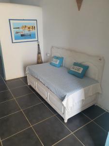 a bed in a room with blue pillows on it at Dar Chick Yahia Ile De Djerba in Mezrane