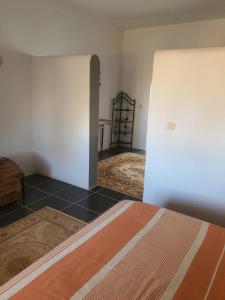 a bedroom with a bed and a room with a closet at Dar Chick Yahia Ile De Djerba in Mezrane