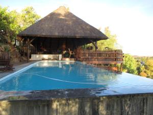 a large swimming pool with a thatched gazebo at The Overlook in Keimoes