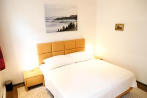 sypialnia z białym łóżkiem i obrazem na ścianie w obiekcie «Go West» guest rooms w Wiedniu