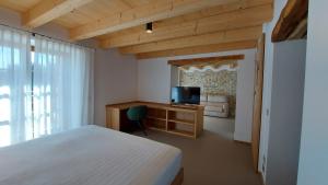 una camera da letto con un letto e una televisione di Corte Varola B&B Zia Marisa a Belluno