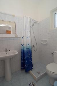 a bathroom with a shower and a toilet and a sink at Hotel Tassia for families & couples in Laganas