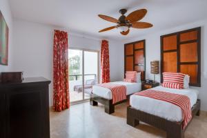 a bedroom with two beds and a ceiling fan at Las Terrazas Resort in San Pedro