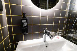 a bathroom sink with a bottle of rock your room soap at ibis Lviv Center in Lviv