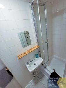 a bathroom with a sink and a shower at Palatine Court Holiday Flats - Blackpool Resort Collection in Blackpool
