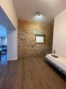 a bedroom with a brick wall and a bed at Pokoje Gościnne Atelier in Orneta