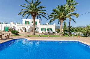 una piscina frente a una casa con palmeras en YourHouse Goet, villa with private pool, en Sa Pobla