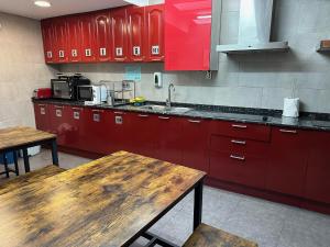 een keuken met rode kasten en een houten tafel bij Hostal Alogar in Barcelona