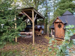 a small wooden shelter with a table and a table at The Hobbit House and Secret Garden in Taunton