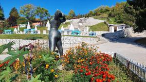 uma estátua de uma mulher num jardim com flores em Apartman ALMA em Kalesija