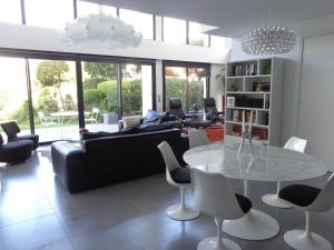 a living room with a couch and a table and chairs at LOFT Le MARELLA in Royan