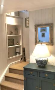 a room with a staircase and a lamp on a cabinet at Lovely 2 bed annexe near Salisbury in Salisbury