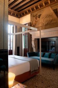 Palazzo Maria Formosa في البندقية: غرفة نوم مع سرير مزدوج كبير وأريكة