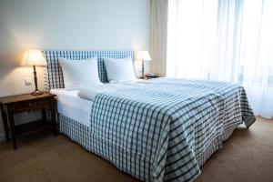a bedroom with a bed with a blue and white blanket at Altstadthotel Messerschmitt in Bamberg