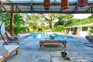 un patio con piscina, mesa y sillas en Tribe Boutique Hotel - Adults Only, en Dominical