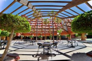 a patio with chairs and tables in a building at Holiday Premium Resort in Benalmádena
