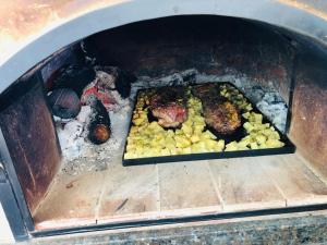 a oven with meat and vegetables in it at Casa quinta La Justina in Concepción del Uruguay